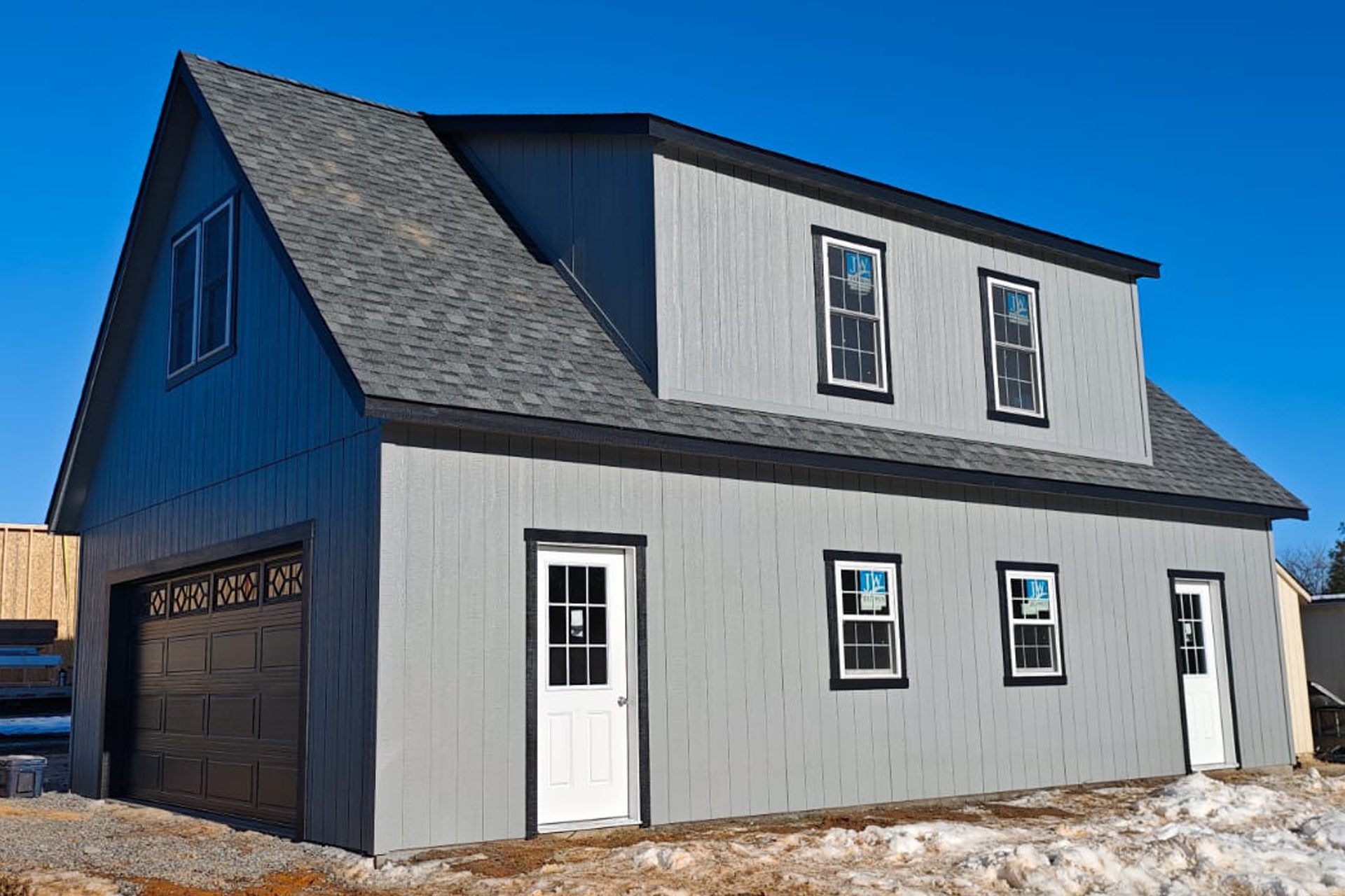 Garage with exterior door leading up the living space on the second floor