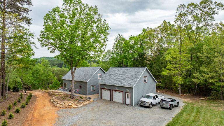 Aerial Photo of the new color matched 24x40 2-car garage workshop with attic placed next to the primary residence in the rear over looking the valley