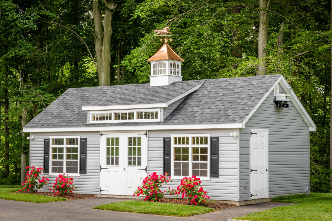 a gray shed with black shutters and white doors and windows for say in Lynn, MA