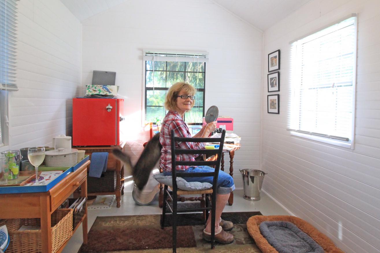 women sitting in chair at desk inside shed creating cookbooks