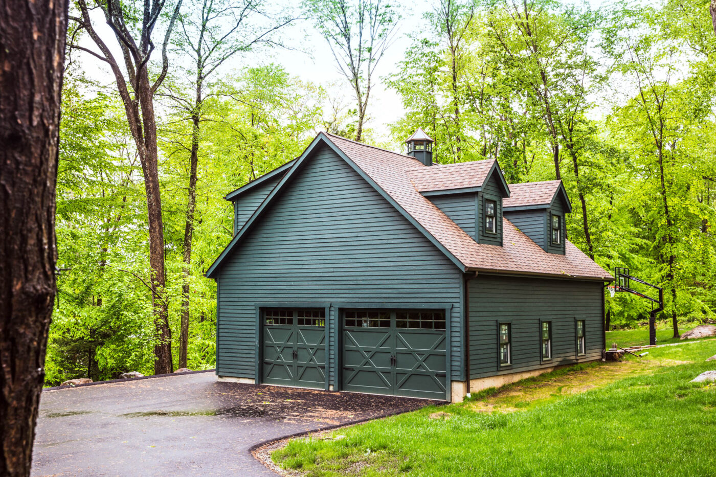 black garage with red shingle roof