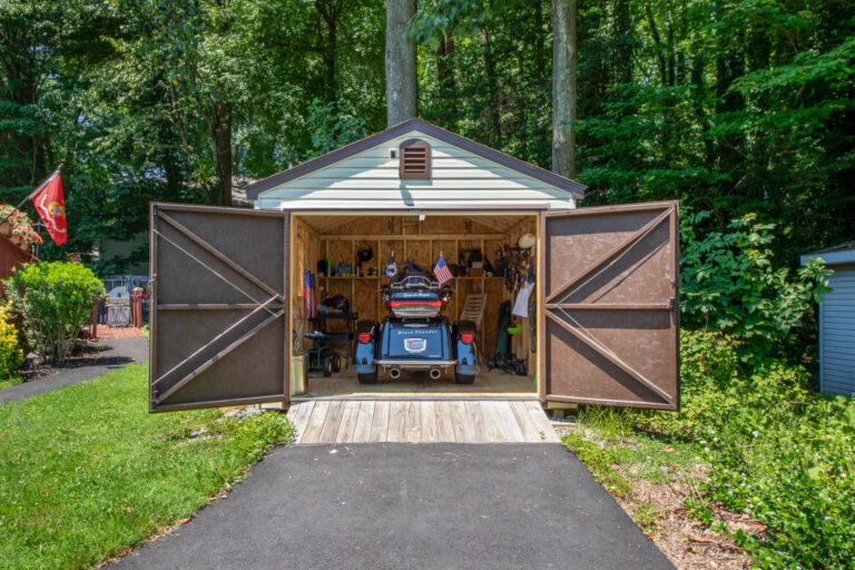 an Antique Ivory 10x12 Standard Workshop Shed in Annapolis, MD with Dark Brown double doors and a ramp