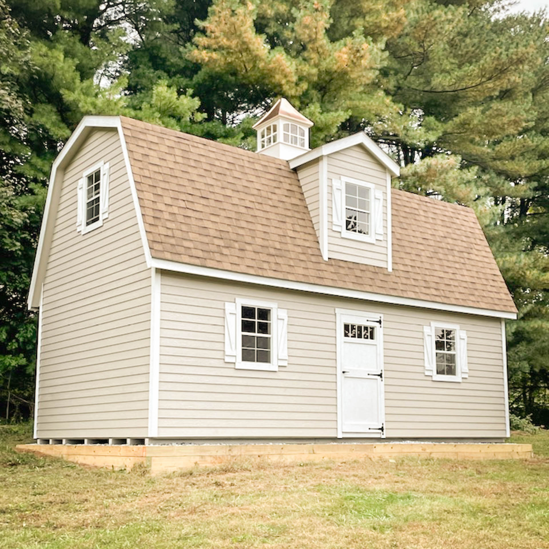 the exterior of a custom painted 2-Story MaxiBarn shed in West Chester, PA with white trim, white z shutters, and Earthtone Cedar shingles