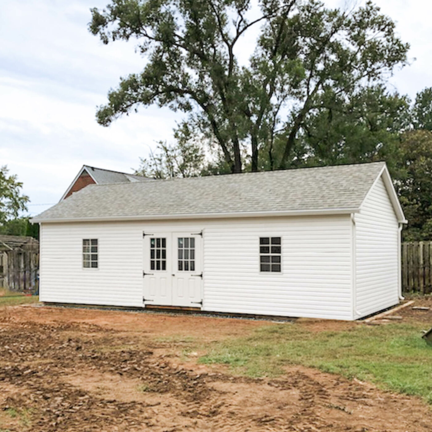 the exterior of a white classic workshop shed in savage, md with white trim and cobblestone gray shingles