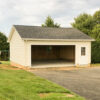 the exterior of a 24x24 workshop 2-car garage in Mt. Airy, MD with sandstone beige custom vinyl siding and a black roof
