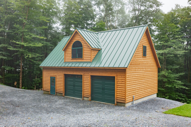 A 24x36 garage in Stamford, VT with pine log siding.