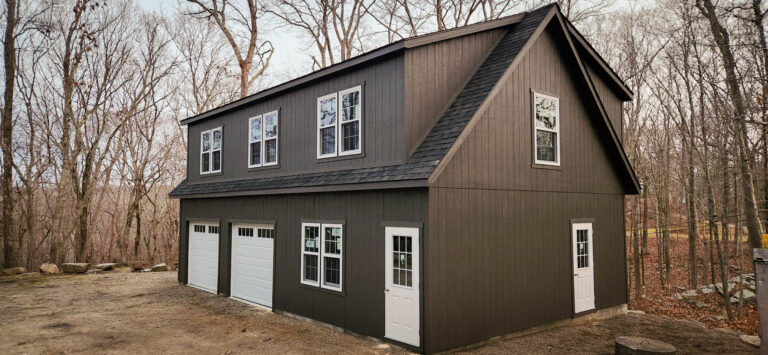 the exterior of an dark grey workshop 2-Car garage in lyme, ct with white windows and doors and black shingles