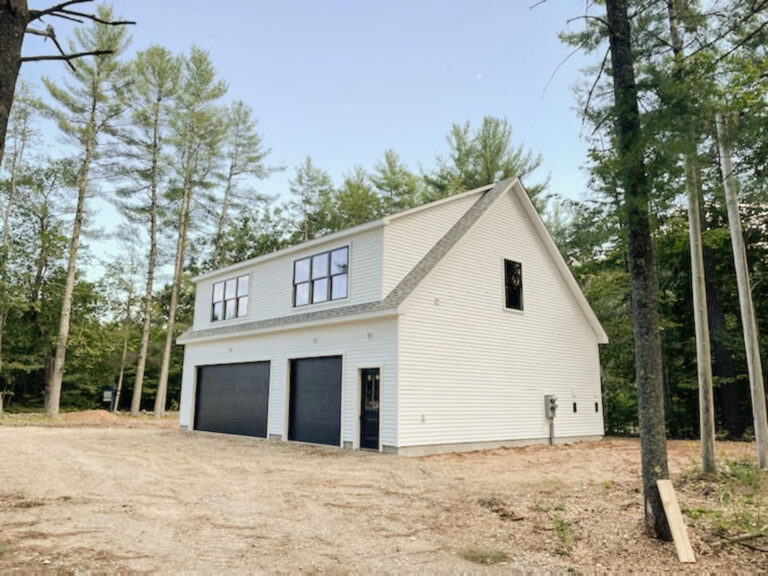 the exterior of a white 2-story Workshop 2-car Garage with black garage doors and a grey roof in Acton, ME