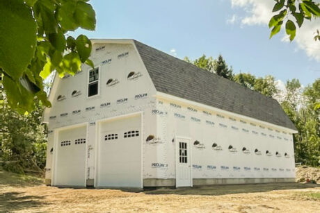 a 28x48 2-Story MaxiBarn 2-Car Garage in cheshire, MA with white garage doors and OSB/house wrap