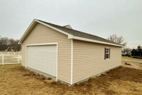 the exterior of a 24x32 single-story workshop 2-car garage in falling waters, wv with white trim and sandstone vinyl siding