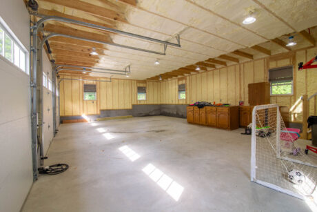 the interior of a white Attic Workshop 3-Car Garage with vinyl siding and black shutters in Carmel Hamlet, NY built by Sheds Unlimited