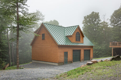 A 24x36 garage in Stamford, VT with pine log siding.