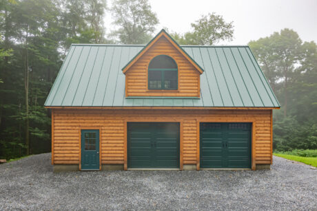 A 24x36 garage in Stamford, VT with pine log siding.