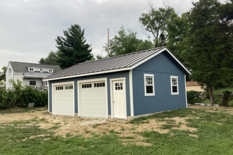 A blue 2-car prefab workshop garage with black standing seam metal roof