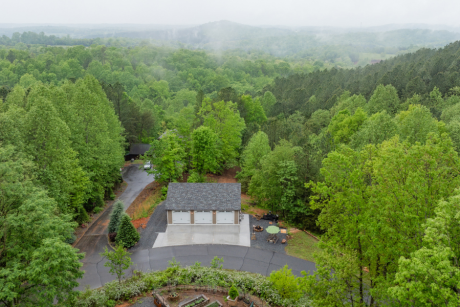 aerial view of a tan and white trimmed garage with a dual gray shingle roof