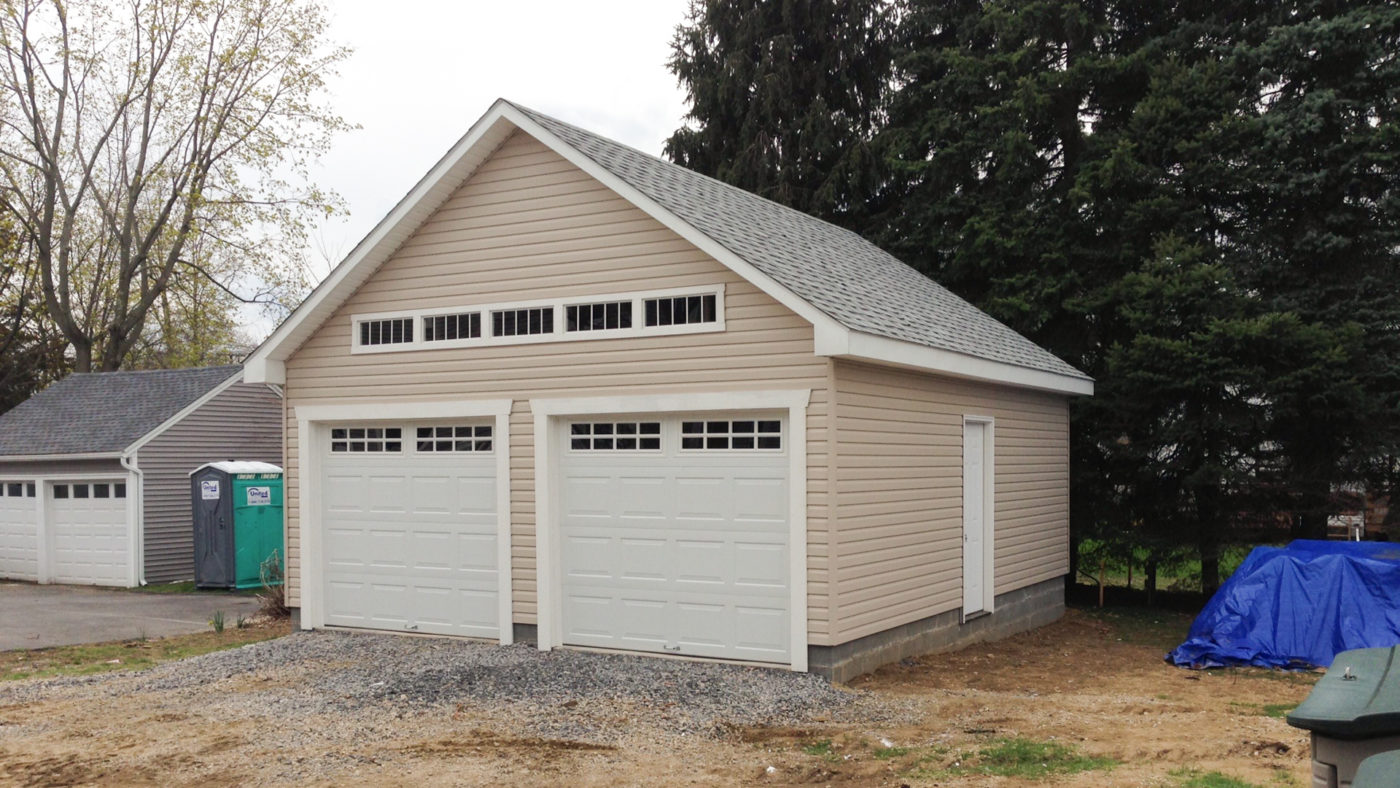 exterior photo of tan and grey amish built garage for sale