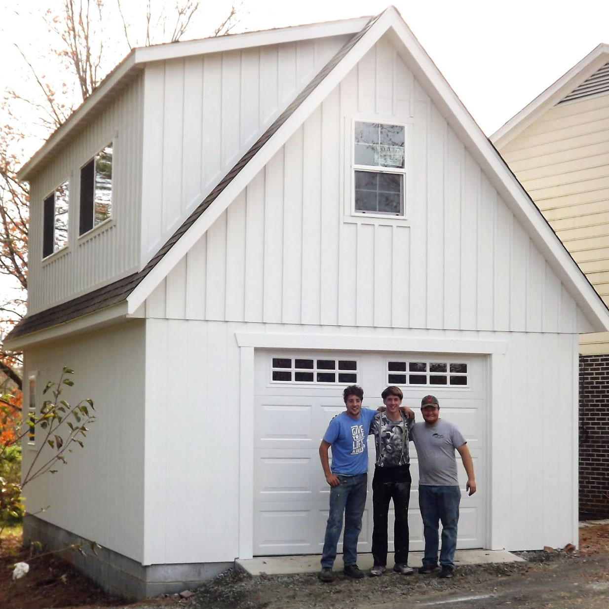 exterior of white board and batten garage with team for customer story