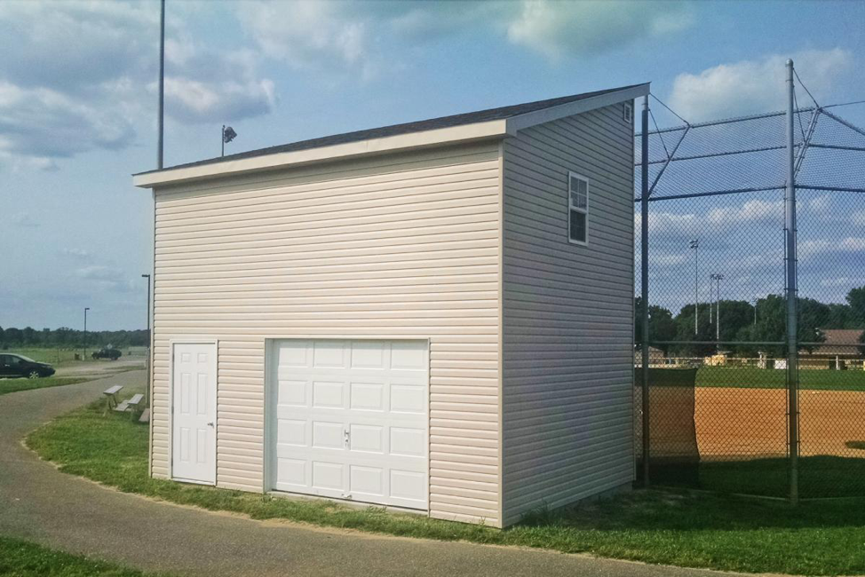 exterior of baseball storage shed by a baseball field