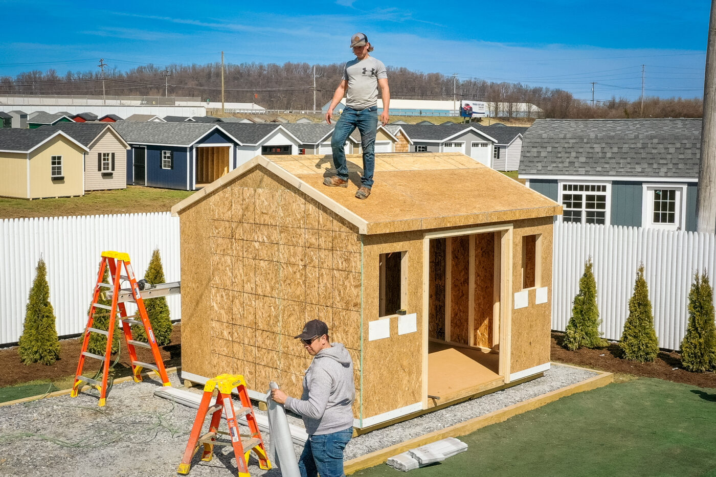 This photo showcases a skilled roofer installing shingles on a newly constructed shed from one of Sheds Unlimited's DIY Shed Kits. The process ensures proper waterproofing and long-term durability, making the shed more resilient to the elements.