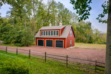 A 24x38 2-story 3-car garage with red siding and cupolas