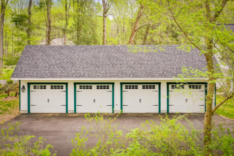 front view of a wood 24x48 garage in Fulton, MD with green trim in a forest