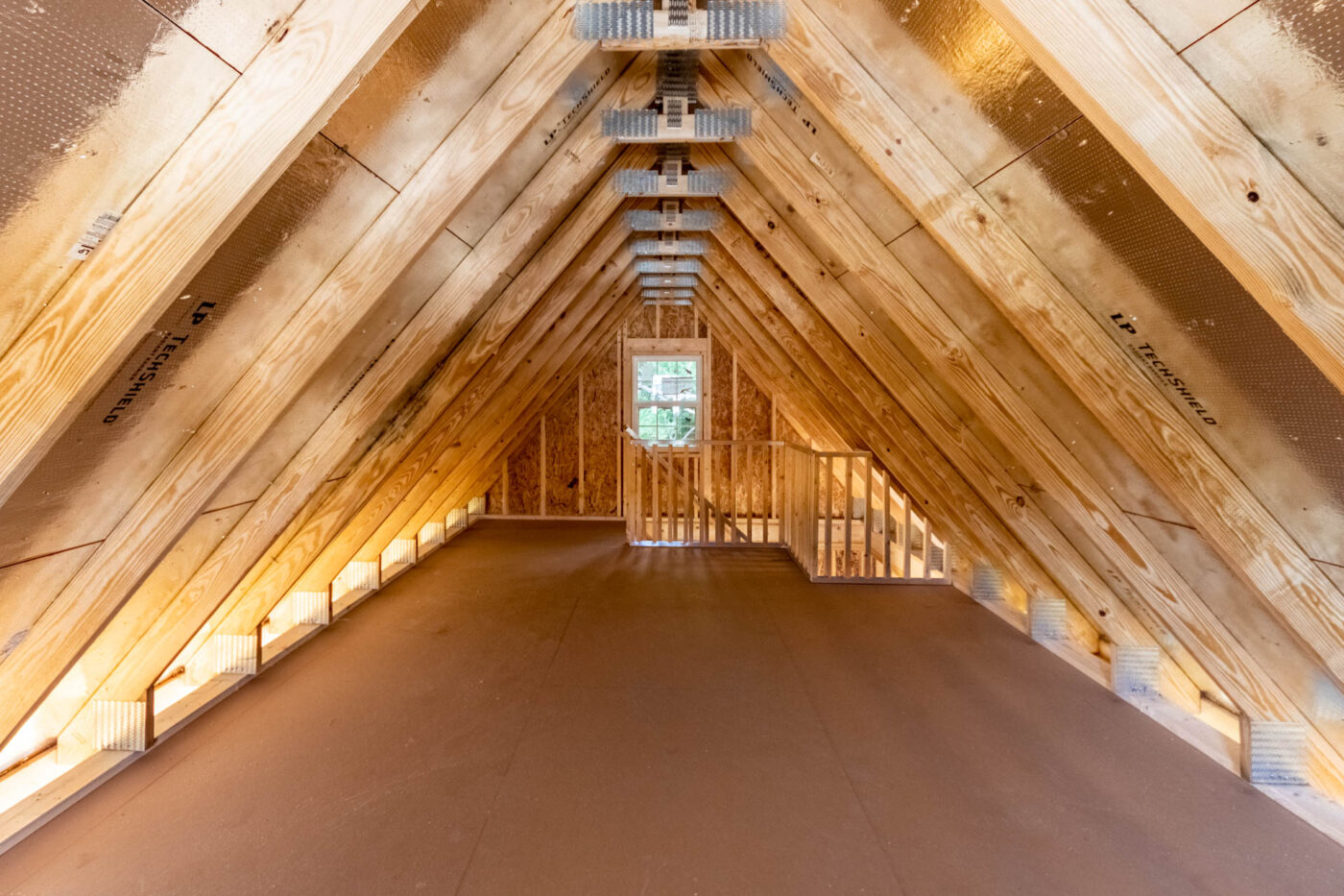 The interior of a garage with attic trusses.